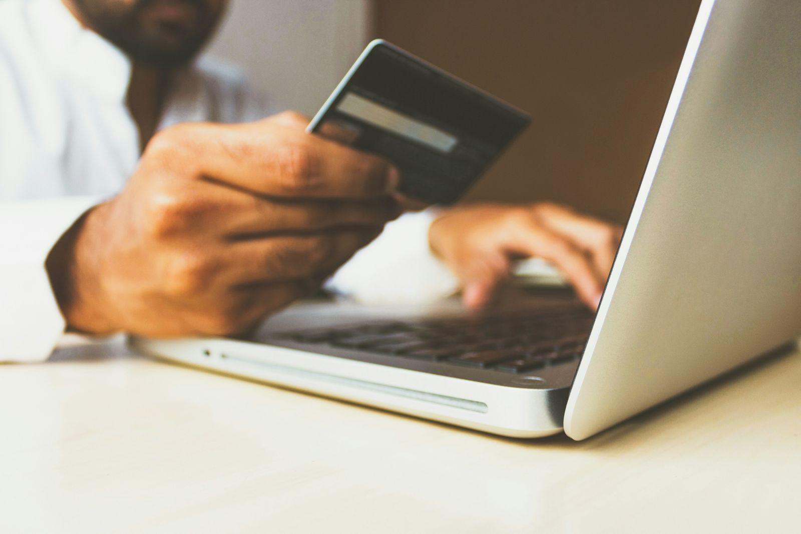 banking-and-finance Banking and finance law: person holding a bank card while using a laptop